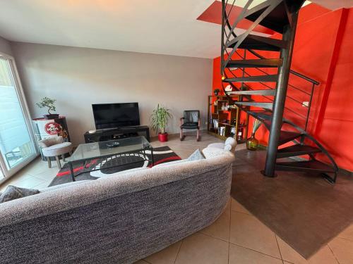 a living room with a couch and a spiral staircase at Le Yéti T4 air-conditioned Lyon Eurexpo stadium LDLC arena in Chassieu
