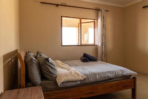 a bed in a room with a window at Rain Tree Camp in Chunga