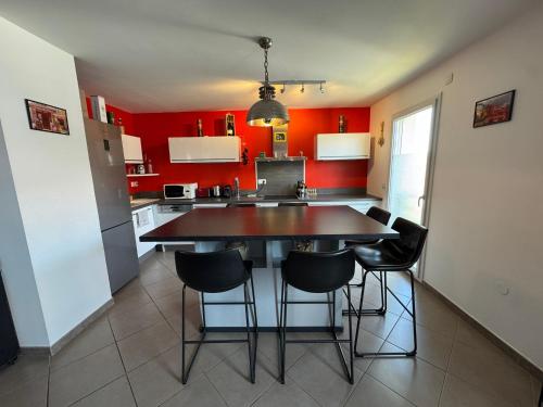 a kitchen with red walls and a table and chairs at Le Yéti T4 air-conditioned Lyon Eurexpo stadium LDLC arena in Chassieu