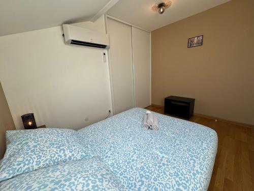 a bedroom with a bed with a blue comforter at Le Yéti T4 air-conditioned Lyon Eurexpo stadium LDLC arena in Chassieu