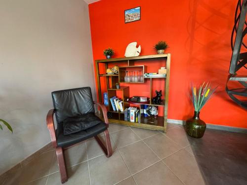 a black chair in a room with an orange wall at Le Yéti T4 air-conditioned Lyon Eurexpo stadium LDLC arena in Chassieu