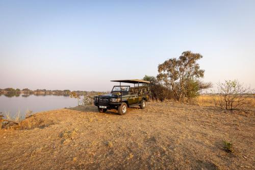 a jeep parked next to a body of water at Rain Tree Camp in Chunga