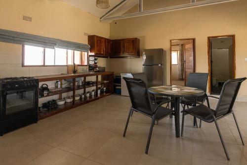 a kitchen with a table and chairs in a room at Rain Tree Camp in Chunga