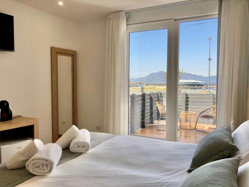 a bedroom with a bed with a view of a balcony at A caseta de Sil in Lira