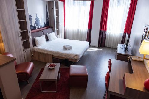 a small room with a bed and a table at B&B HOME Caen Centre Gare in Caen