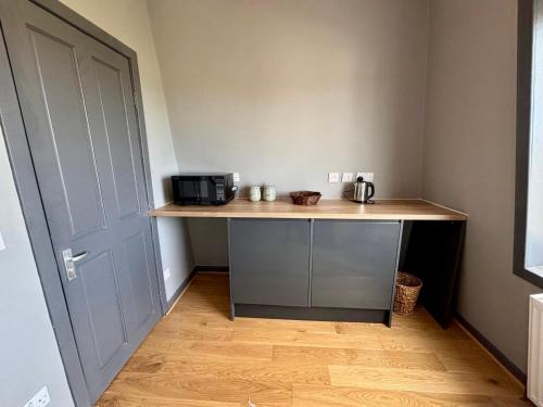 a kitchen with a counter with a microwave and a door at The Hebridean - Rooms & Apartments in Broadford