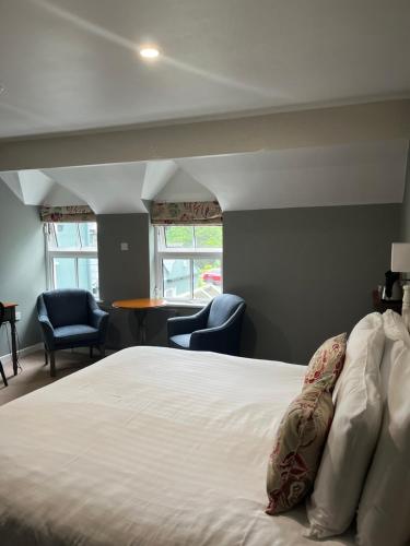 a bedroom with a bed with two chairs and a table at Casey's Of Baltimore Collection in Baltimore
