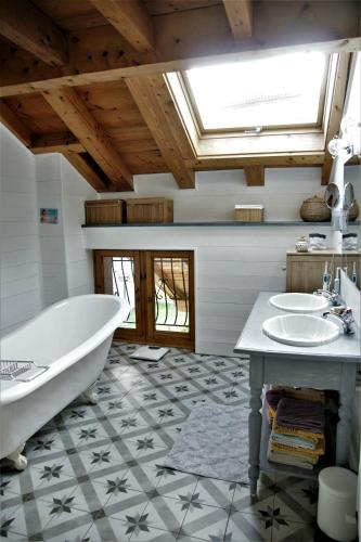 une salle de bain avec une baignoire et un lavabo dans l'établissement Chaleureuse maison de village, à Marignier