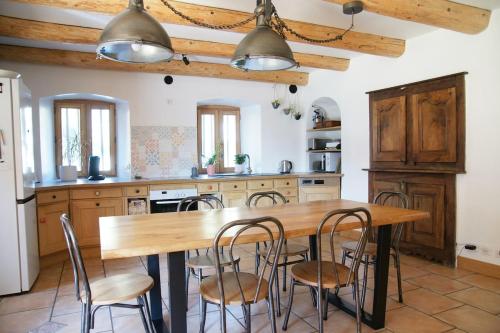 une cuisine avec une table et des chaises en bois dans l'établissement Chaleureuse maison de village, à Marignier