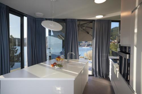 - une cuisine avec un comptoir blanc et de grandes fenêtres dans l'établissement Villa Bonaca, à Korčula