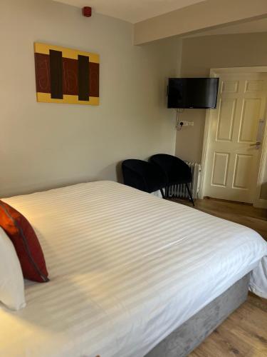 a bedroom with a large white bed and a television at Casey's Of Baltimore Collection in Baltimore