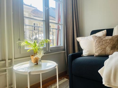 a living room with a couch and a table and a window at central bijou in Thun