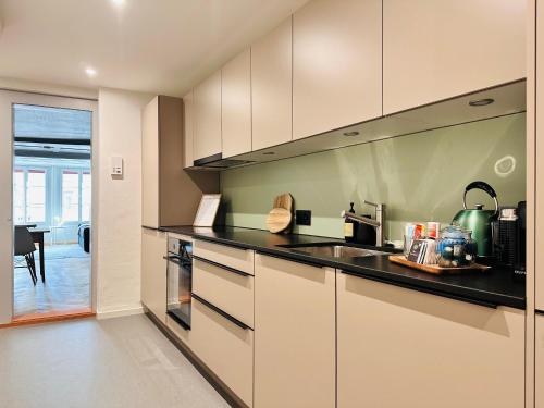 a kitchen with white cabinets and black counter tops at central bijou in Thun