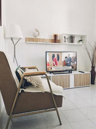 a living room with a tv and a chair at Pina House in Pêra
