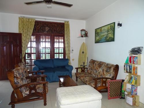 a living room with a blue couch and chairs at Ceylon Glory Hostel in Negombo