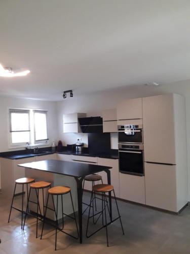 - une cuisine avec une table et quelques tabourets dans l'établissement Maison Almanarre, à Hyères