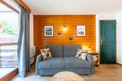 a living room with a couch and a window at You Ski en Terre Happy G11 in Valloire