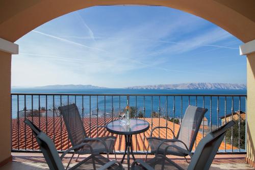 a balcony with chairs and a table and the ocean at Seabreeze Apartments with Shared Jacuzzi in Senj