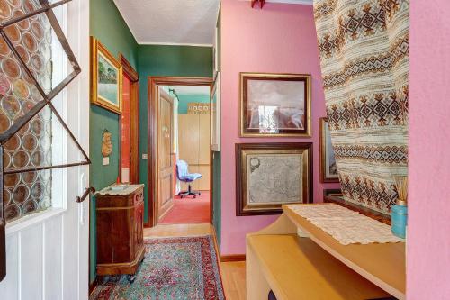 a hallway with pink and green walls and a door at Vacanza Natura, Montagne e Laghi in Omegna