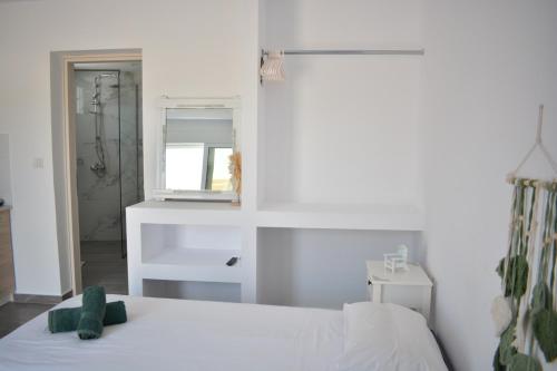 a white bedroom with a bed and a shower at Tommy's Rooms in Haraki