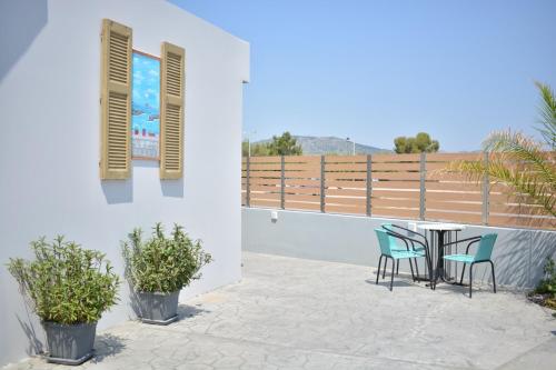 a patio with a table and chairs on a balcony at Tommy's Rooms in Haraki