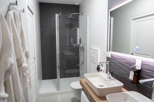 a white bathroom with a sink and a shower at Villa Saint-Lager - Séjour de charme au cœur du Beaujolais in Saint-Lager