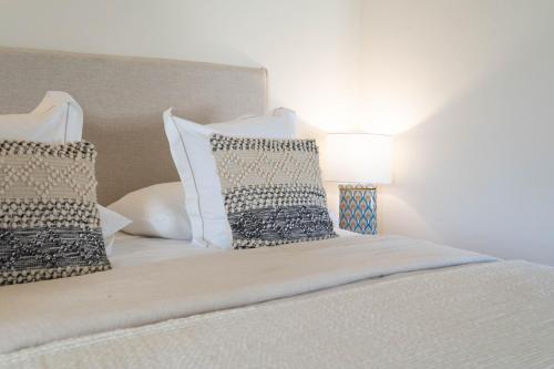 a white bed with pillows and a lamp on it at Reserva Rotana Golf Resort in Manacor