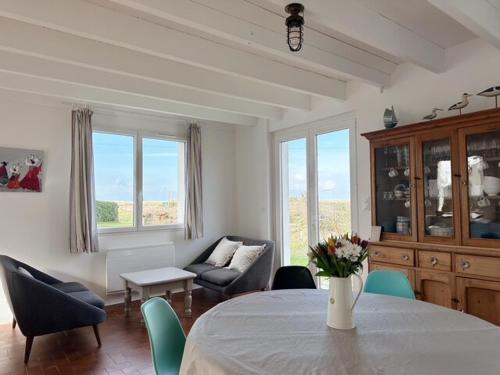 un salon avec une table, des chaises et un canapé dans l'établissement Maison du Crémiou en bord de mer, à Kerlouan