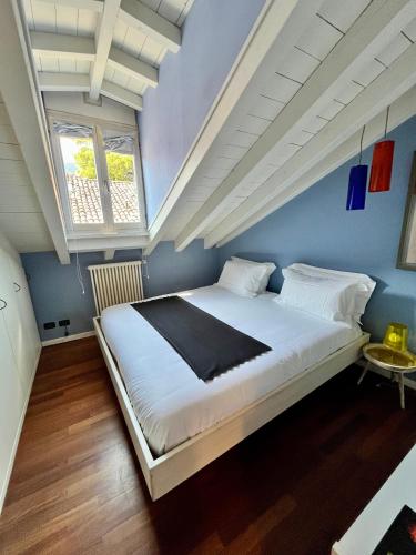 a bedroom with a large bed in a blue wall at Vanessa's Art Rooftop Attic - City View - San Fedele, Historic Center Como in Como