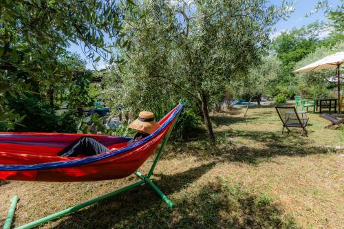 a person sitting in a hammock in a park at Il Laghello Wood House in Framura