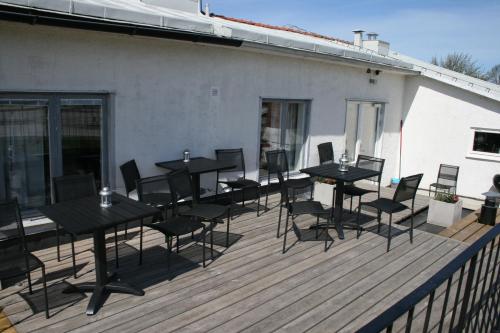 a group of tables and chairs on a deck at Visby Innerstad Lägenheter & Rum in Visby