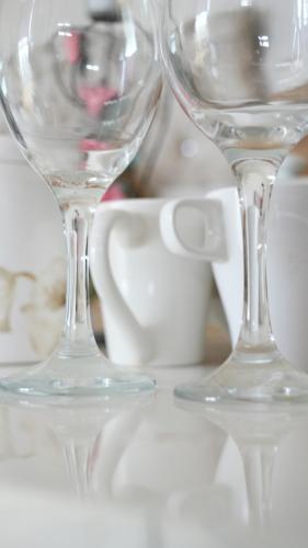 two wine glasses sitting on top of a table at Lux Apartment in Gatwick in Crawley