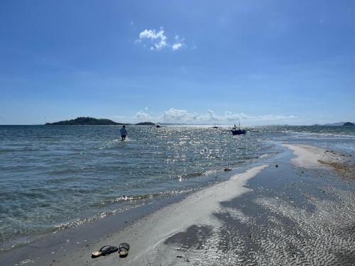 a man standing in the water at the beach at Port Kalaya in El Nido