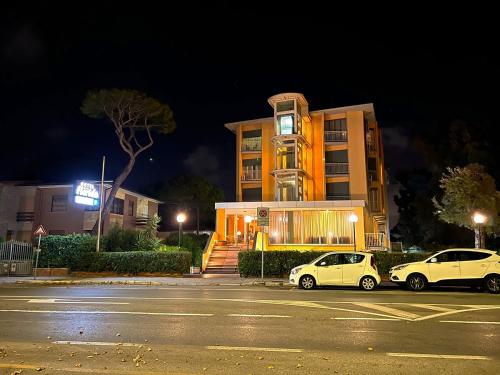 two cars parked in front of a building at night at Hotel Florida Tirrenia in Tirrenia