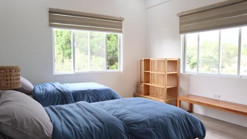 a bedroom with two beds and two windows at Port Kalaya in El Nido