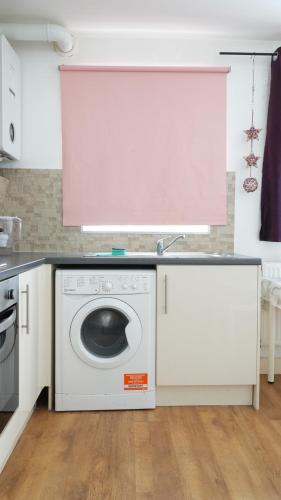 a kitchen with a washing machine and a sink at Lux Apartment in Gatwick in Crawley