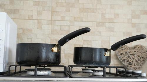 two pots sitting on top of a stove at Lux Apartment in Gatwick in Crawley