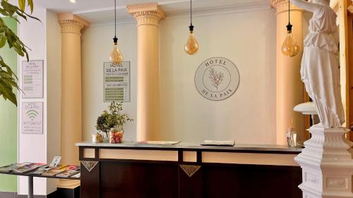 a counter in a room with columns and lights at Hôtel de la paix in Limoges