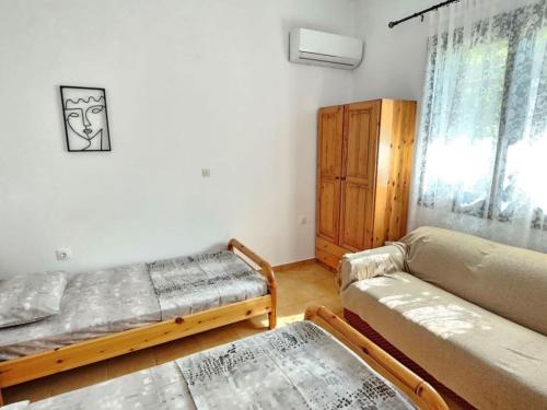 a bedroom with a bed and a couch and a window at Skyros BnB Calliope in Molos in Skiros