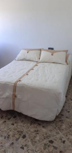 a white bed with white sheets and pillows at Cortijo Rural Buenavista Montefrio in Montefrío