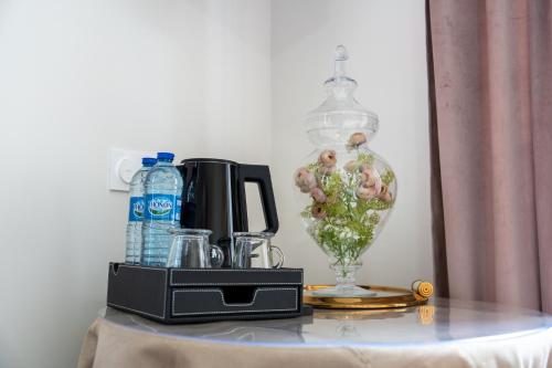 a table with a glass vase on top of it at Villa Saint-Lager - Séjour de charme au cœur du Beaujolais in Saint-Lager
