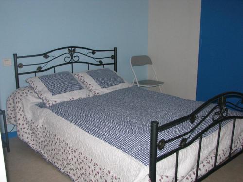 une chambre avec un lit avec un mur bleu dans l'établissement Appartement 2 chambres proche de la plage, à Royan