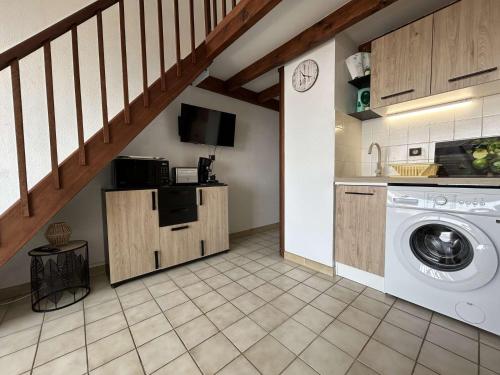 une buanderie avec un lave-linge et un escalier dans l'établissement SP080-026 Appt T2 mezzanine 4 couchages SAINT PIERRE LA MER, à Saint Pierre La Mer