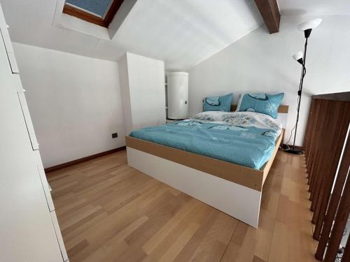 Cette chambre comprend un lit avec des draps bleus et du parquet. dans l'établissement SP080-026 Appt T2 mezzanine 4 couchages SAINT PIERRE LA MER, à Saint Pierre La Mer