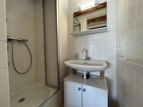 une salle de bain blanche avec un lavabo et une douche dans l'établissement SP080-026 Appt T2 mezzanine 4 couchages SAINT PIERRE LA MER, à Saint Pierre La Mer