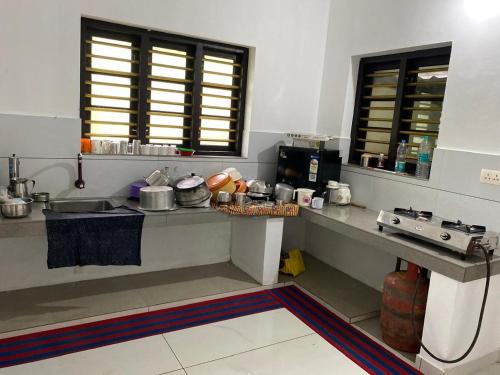 a kitchen with a counter with pots and pans at Thiruthi Homestay in Vallikunnu