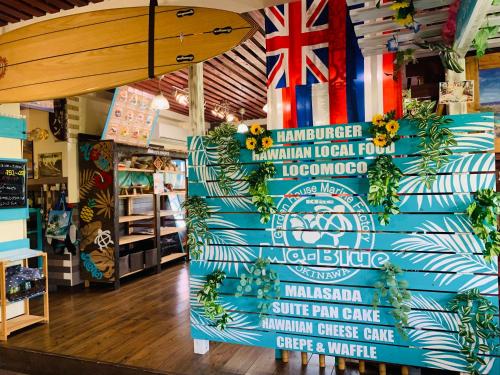 a store with a surfboard and signs on the wall at Ma-Blue Garden House in Motobu