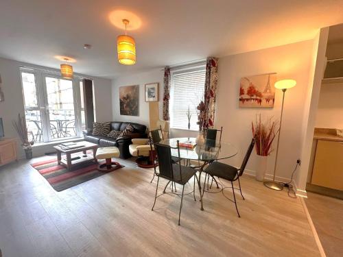 a living room with a glass table and a couch at Chichester City Centre 2 Bedroom Flat I Ground Floor with Underground Parking I Chichester Holiday Properties in Chichester