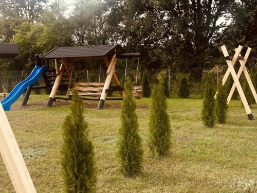 un parque infantil con un columpio y un tobogán en LandsBy Apartments, en Ostrów Warcki