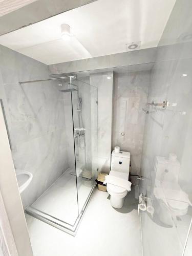 a white bathroom with a toilet and a shower at North Star Hotel in Yakkasaray